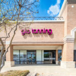 A glo tanning salon, being inside a red brick building.