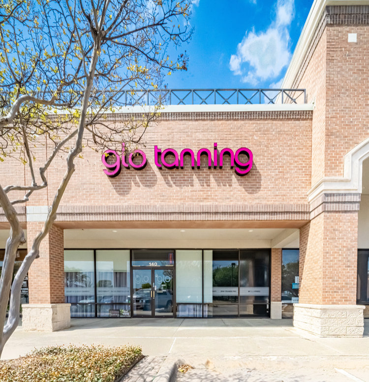 A glo tanning salon, being inside a red brick building.